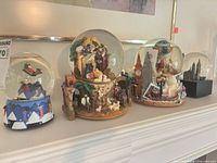 Group shot of all four snow globes on shelf