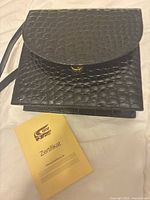 Front view of bag with flap open, certificate visible