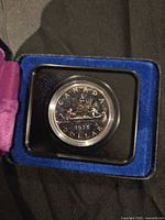 Coin in capsule within open presentation case