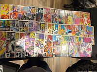 Wide shot of roughly thirty bagged Alpha Flight comics laid out in two rows on a table
