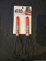 Front view of two red-handled silicone whisks on Star Wars card