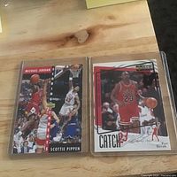 Two Upper Deck cards in plastic sleeves on table