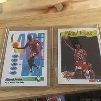 Both Michael Jordan cards in protective sleeves side by side