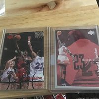 Both Michael Jordan cards side by side in sleeves