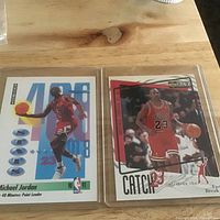 Both Michael Jordan trading cards in protective sleeves displayed side by side