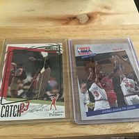 Two Michael Jordan cards side by side in sleeves