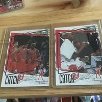 Two Michael Jordan Catch 23 cards in sleeves on tabletop