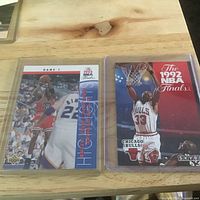 Two trading cards in sleeves: Upper Deck Jordan Game 1 NBA Finals and SkyBox 1992 NBA Finals