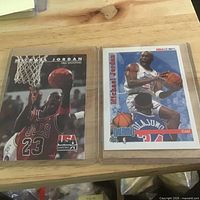 Both Michael Jordan cards side by side in sleeves