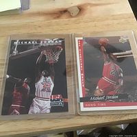 Both Michael Jordan cards in protective sleeves