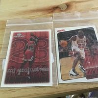 Both Michael Jordan cards in protective sleeves side by side