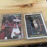 Both Michael Jordan trading cards in sleeves side by side