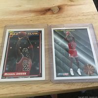 Both Michael Jordan cards in protective sleeves displayed side by side