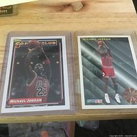 Two Michael Jordan cards side-by-side in sleeves: Topps 50 Point Club and Fleer League Leader
