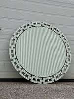 Full view front of round mirror leaning against wall