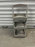 Full frontal view of beige ladder caddy showing three tiers