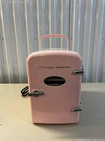 Front view showing pink exterior, logo, chrome latch, handle and power cord