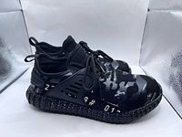 Side view of both shoes showing camouflage pattern and midsole graphics