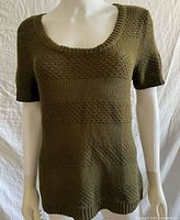 Front view of olive knit short-sleeve shirt on mannequin