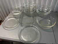 Overhead view of 12 Pyrex glass bakeware pieces arranged on table