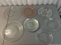 Seven of the eight glass plates laid out showing different patterns