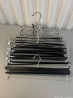 Stack of nine metal multi-tier hangers with black bars
