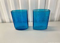 Front view of the two blue hand-blown square vases