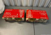 Two boxed sets of Anchor Hocking Arlington punch cups on table