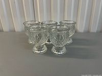 Group of five clear pressed-glass votive candle holders