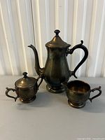 Overview of three silverplate pieces: teapot, creamer, sugar bowl