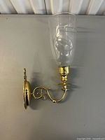 Full view of brass sconce with attached glass chimney