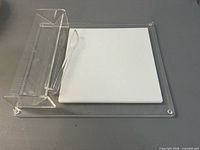 Top view of acrylic tray with white tile insert and tongs
