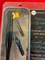 Close view of pen holder and two nibs inside sealed packaging