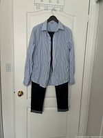 Full view of both the jeans and dress shirt hanging