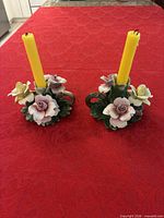 Both Capodimonte floral candlesticks with yellow candles for scale