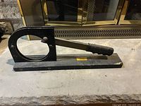 Full view of metal fire log cutter on hearth