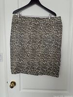 Full front view of skirt on hanger showing print and pocket zippers