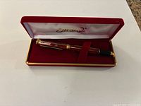 Pen inside red velvet case with lid open