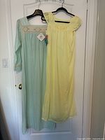 Two nightgowns on hangers: aqua long-sleeve, lemon sleeveless