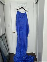 Full length view of blue silk sari fabric draped on hanger showing overall size