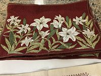 stack of red floral tapestry placemats