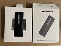 Front view of adapter inside open box alongside closed retail box