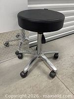 Full view of adjustable rolling stool showing seat, base and casters