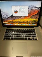 MacBook Pro open, displaying desktop and hardware overview