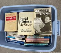 Blue tote containing dictionary, English autobiography, Chinese health book and stacked Chinese paperbacks
