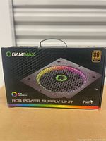 Front of GameMax PSU box displaying RGB fan image, wattage and 80 PLUS Gold badge