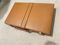 Closed tan faux-leather case with latch hardware