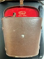 Brown leather hard case open showing red interior and Apollo triple tested logo