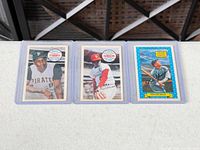 Full view of the three vintage Topps baseball cards in sleeves