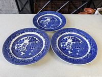 Three Blue Willow plates front view showing pattern and wear
